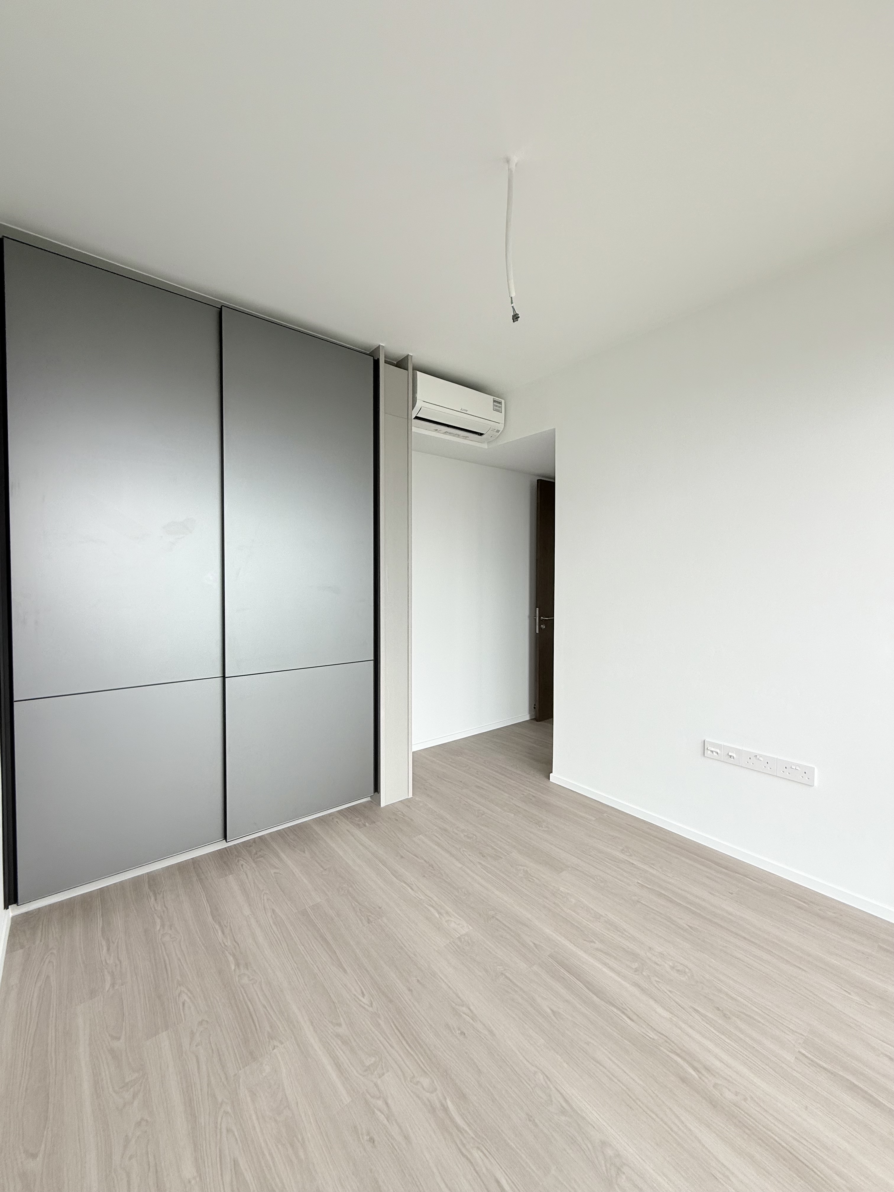 Brand new bedroom at AMO Residence with wardrobe and light flooring
